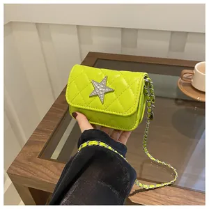 Detail of lime green quilted crossbody bag featuring a silver rhinestone star and chain strap