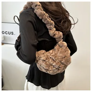 Brown plush pleated cloud bag styled as a shoulder bag on a model, soft texture view