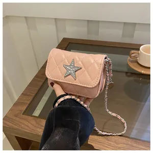 Close-up of pink quilted mini bag with crystal star and silver chain strap