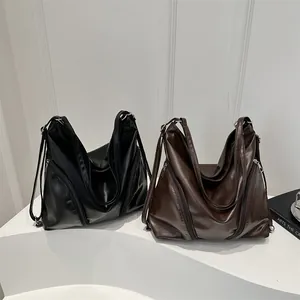 Minimalist soft PU leather tote bag in black and dark brown with functional side zippers