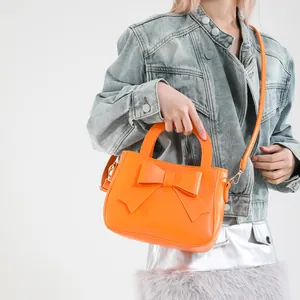 Borsa a mano arancione brillante con decorazione a fiocco grande e finitura in ecopelle