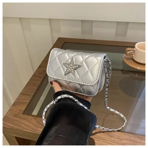 Detail of silver quilted mini bag featuring rhinestone star buckle and chain strap