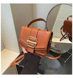 Detail der orangefarbenen Vintage-Handtasche aus Leder mit großer Gold-Schnalle