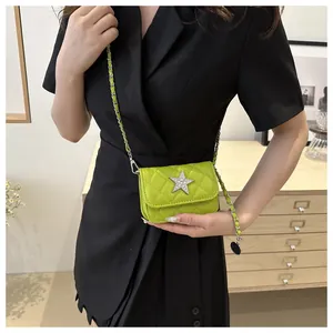 Close-up of neon green quilted crossbody bag with sparkling star and silver chain strap