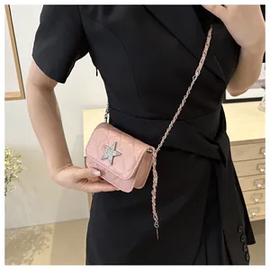 On-body view of pink quilted crossbody bag with silver sequin star and chain strap
