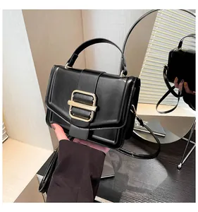 Detailansicht einer schwarzen Handtasche mit goldener Schnalle im Schminkspiegel