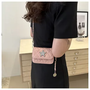 Pink quilted crossbody bag detail with sparkling star ornament and chain strap on model