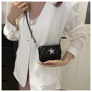 Quilted diamond chain bag with silver star detail shown on a white blazer outfit