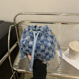 Blue denim patchwork bucket bag with checkered pattern and frayed edges for daily commute