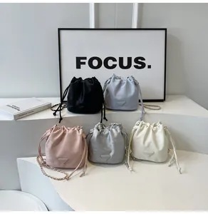 Vue détaillée de sacs seaux à cordon en cinq couleurs avec bandoulières en chaîne