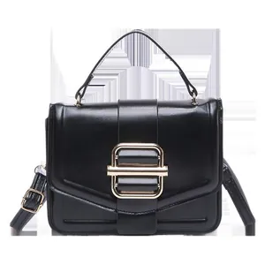 Klassische schwarze glänzende Ledertasche mit Goldschnalle und verstellbarem Riemen auf Weiß