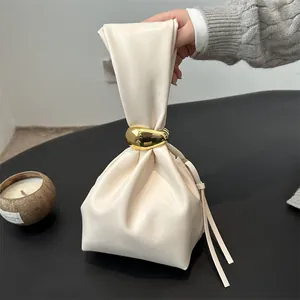 Sac seau plissé blanc cassé chic doté d'un grand anneau doré décoratif sur l'anse