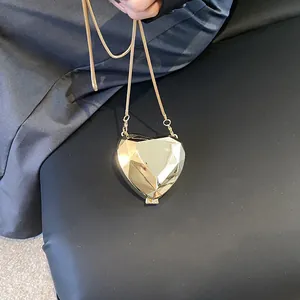 Golden heart-shaped acrylic evening bag with faceted diamond-cut design and gold chain strap