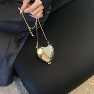 Elegant gold heart-shaped metal evening clutch bag with faceted geometric design and chain