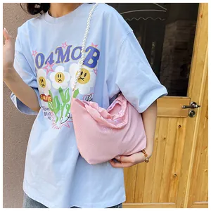 Pink fabric crossbody bag featuring a white pearl strap and Good embroidery detail