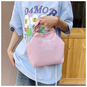 Detail of pink knitted texture bag with bow embroidery and pearl bead chain strap