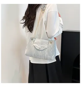 Detail der silbergrauen Tasche mit Faltenstruktur und Goldkette an einem Model
