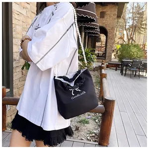 Detail of black bow fabric tote bag with GoodLuck embroidery and pearl chain strap