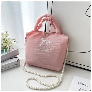 Detail of pink waffle fabric texture with bow embroidery and elegant pearl chain