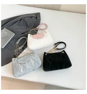 Nahaufnahme von Plissee-Schultertaschen in Rosa, Silber und Schwarz mit Goldketten
