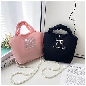 Close-up of pink and black waffle texture handbags with bow embroidery and pearl chain