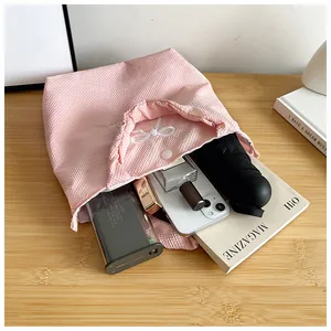 Pink bubble texture handbag showing spacious interior with phone, umbrella and cosmetics