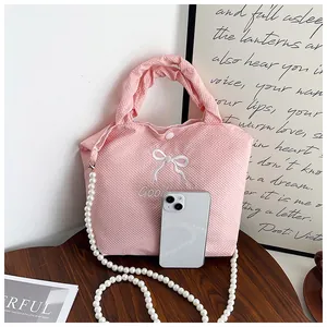 Close-up of pink waffle texture tote bag with bow embroidery and pearl chain strap