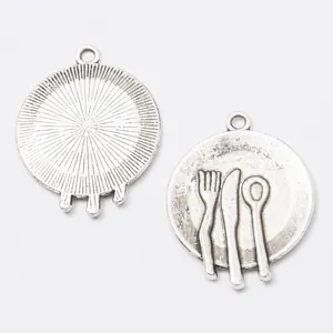 Macro detail of vintage silver alloy plate charm with fork and spoon for DIY jewelry making
