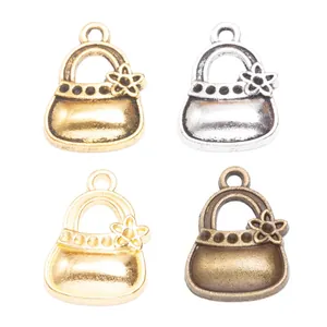 Set of four vintage zinc alloy handbag pendants in gold, silver, bronze, and copper finishes