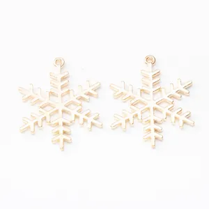 Dettaglio di ciondoli a fiocco di neve dorati in metallo per creazione di gioielli DIY