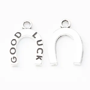 Macro-opname van hoefijzervormige bedeltjes in retro zinklegering met Good Luck gravure