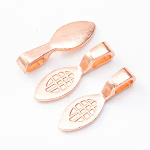 Macro detail of leaf-shaped rose gold plated jewelry pendant bails with grid patterns
