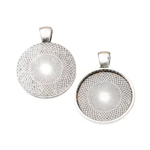 Macro shot of 25mm vintage silver pendant trays with intricate starburst engravings
