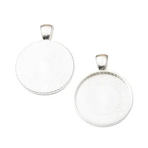 Detail showing two silver zinc alloy round pendant trays with spiral texture and bails