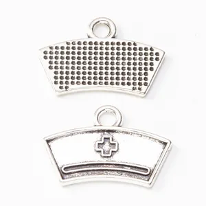 Vintage zinc alloy nurse hat pendants showing front cross detail and textured back