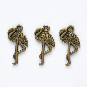 Detailed view of three vintage bronze flamingo pendants for DIY jewelry making