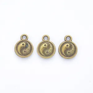 Three vintage bronze Yin Yang charms for DIY jewelry making on white background