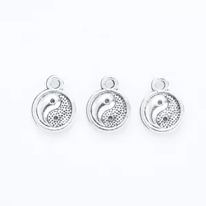 Close-up of three vintage silver Tai Chi Yin Yang alloy pendants for DIY jewelry making