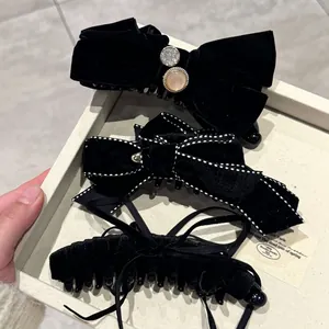 Tres elegantes pinzas para el pelo de terciopelo negro con perlas y lazos en bandeja