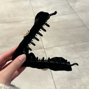 Pinza tipo banana de terciopelo negro con botón vintage dorado y dientes de plástico