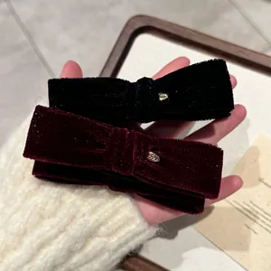 Vue détaillée des barrettes nœuds en velours avec breloque cœur pour automne hiver