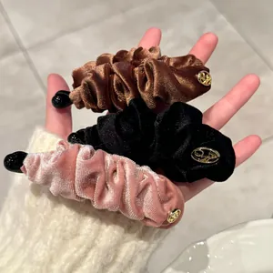 Barrettes banane en velours à double nœud en marron, noir et rose avec logo doré chic