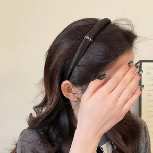 Detail of elegant black satin headband with silver rhinestones on female model