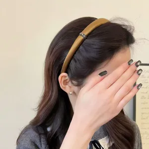 Close-up of elegant brown satin headband with sparkling rhinestone buckle on a female model