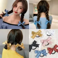 Detail of elegant bow hair ties with houndstooth patterns shown on braided hairstyles
