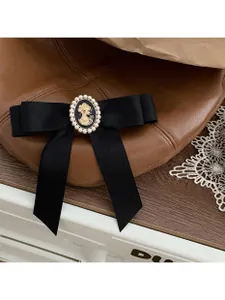 Detail einer Vintage-Cameo-Brosche auf schwarzer Satinschleife mit Perlenverzierung