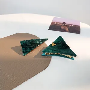 Detail von grünem Marmor-Haarclip und Haarklammer mit eleganten Goldanhängern