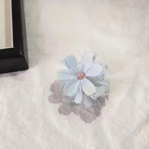 Detail view of a light purple fabric flower hair claw clip with delicate beaded stamen