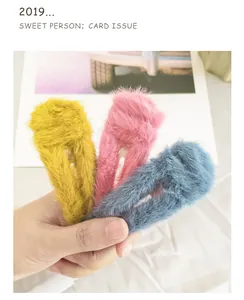 Detailed view of plush faux rabbit fur hair clips in yellow pink and blue colors