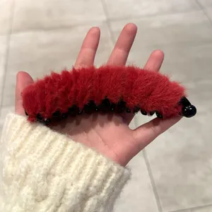 Détail du clip banane en peluche rouge avec dents de préhension internes en plastique